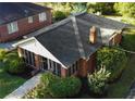 Aerial view of a charming red brick home with a well-maintained yard, mature trees, and a classic roof at 2791 Pearl St, East Point, GA 30344