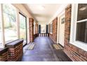 Long front porch with brick walls, windows, and two black and white rugs at 2791 Pearl St, East Point, GA 30344