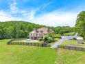 Expansive estate featuring a pool, fenced yard, lush greenery, and a charming rear exterior at 714 Billings Farm Ln, Canton, GA 30115