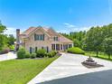 Beautiful brick home with a well-manicured lawn, mature trees, and a circular driveway with a water fountain at 714 Billings Farm Ln, Canton, GA 30115