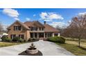 Beautiful brick home featuring a circular driveway with a fountain, complemented by lush landscaping at 714 Billings Farm Ln, Canton, GA 30115