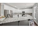 Modern kitchen with white cabinets, stainless steel appliances, granite countertops, and a stylish backsplash at 2995 Barimore, Dacula, GA 30019