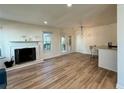 Open living area with wood floors, a fireplace, and a view into the bar with seating at 1395 W Booth Road Sw Ext, Marietta, GA 30008