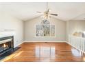 Bright living room with hardwood floors, fireplace, ceiling fan, and a large arched window at 158 Ashwood Drive Dr, Dallas, GA 30157