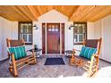 Charming front porch with rocking chairs, brick flooring, and a wood-paneled ceiling at 180 Saddle Creek Dr, Roswell, GA 30076