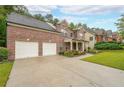 Spacious driveway leading to a brick home with a two-car garage and well-manicured landscaping at 4007 Fellowship Dr, Buford, GA 30519