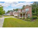 Well-maintained brick home with a two-car garage, covered front porch, and lush landscaping in a suburban neighborhood at 4007 Fellowship Dr, Buford, GA 30519