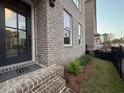 Close up of the brick facade, the front door, and landscaping around the house at 161 Wards Crossing Way # 121, Johns Creek, GA 30022