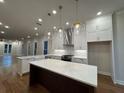 Open concept kitchen with large island, pendant lights, and modern appliances at 161 Wards Crossing Way # 121, Johns Creek, GA 30022