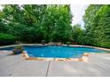 Backyard swimming pool featuring stone accents, lush greenery, and a tranquil atmosphere for relaxation at 1617 Windsor Ne Pkwy, Brookhaven, GA 30319