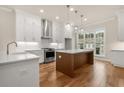 Modern kitchen featuring stainless steel appliances, wood flooring, and a center island for added counter space at 169 Wards Crossing Way # 125, Johns Creek, GA 30022