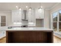 Bright kitchen with stainless steel appliances, wooden island, white cabinets, and farmhouse sink at 169 Wards Crossing Way # 125, Johns Creek, GA 30022