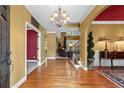 Inviting foyer with hardwood floors, elegant chandelier, and staircase leading to the upper level at 1903 Brackendale Nw Rd, Kennesaw, GA 30152