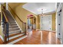 Open foyer with hardwood floors, staircase, chandelier, and access to the dining area at 1903 Brackendale Nw Rd, Kennesaw, GA 30152