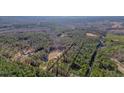 Areal view of multiple houses situated on heavily wooded lots and bordered by dark lines at 1312 Mcgarity Rd, Temple, GA 30179