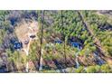 Areal view of multiple houses situated on heavily wooded lots and bordered by dark lines at 1312 Mcgarity Rd, Temple, GA 30179