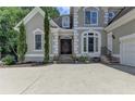 Inviting front entrance with a double-door entry, beautiful trim, and a well-manicured lawn at 4580 Lakefield Bend Bnd, Berkeley Lake, GA 30096