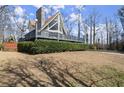 A-frame house featuring a chimney, a large deck, and attractive landscaping in a residential setting at 1364 Tsali Trl, Morrow, GA 30260