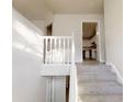 View of the staircase that leads to the kitchen with white cabinets at 1345 Smoke Hill Dr, Hoschton, GA 30548