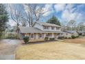 Charming two-story home with brick and siding, shutters, a covered front porch, a two car garage and a spacious front yard at 4481 Buckingham Cir, Decatur, GA 30035