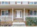 Inviting front porch with brick accents, white railing, columns and trim highlighting the entry of this charming home at 4481 Buckingham Cir, Decatur, GA 30035