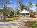 White cottage-style house with a wooden fence, driveway and a well-manicured front lawn at 937 Camilla Sw St, Atlanta, GA 30314