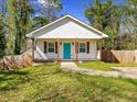 A quaint home with a well-kept lawn, a white exterior, and a cheerful teal front door at 937 Camilla Sw St, Atlanta, GA 30314
