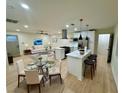 Open-concept living space with modern kitchen, white cabinets, island, stainless steel appliances, and dining area at 2371 Cresta Dr, Decatur, GA 30032