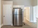 Kitchen featuring stainless steel refrigerator and white cabinets with a doorway looking into the hallway at 5845 Highway 92, Fairburn, GA 30213