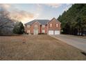 Charming two-story brick home with red shutters and attached two-car garage on a large lot at 6844 Cavalier Ct, Stone Mountain, GA 30087