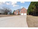 Charming two-story brick home with red shutters and attached two-car garage on a large lot at 6844 Cavalier Ct, Stone Mountain, GA 30087