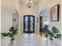 Elegant foyer with arched doorways, tiled floor, and a decorative front door at 477 Glouchester Dr, Locust Grove, GA 30248