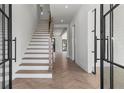 Bright foyer with hardwood floors, a staircase, and elegant glass front doors at 1857 Defoor Ave, Atlanta, GA 30318