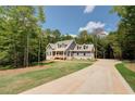 Inviting two-story home with a long driveway and beautiful landscaping at 220 Nicklaus Cir, Social Circle, GA 30025