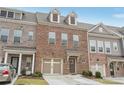 Beautiful brick townhome with an attached garage, manicured lawn, and welcoming entryway at 1566 Ridgebrook Downs, Mableton, GA 30126
