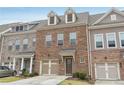 Beautiful brick townhome featuring a one-car garage,dormer windows, and cozy entrance at 1566 Ridgebrook Downs, Mableton, GA 30126