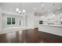 Open-concept living room with hardwood floors, carpeted area, and an adjoining kitchen with modern appliances at 1891 Audubon Park Ln, Decatur, GA 30033