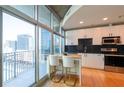 Modern kitchen with white cabinets, stainless steel appliances, and a breakfast bar overlooking the city at 923 Peachtree Ne St # 932, Atlanta, GA 30309