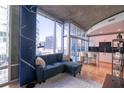 Cozy living room area with a comfortable blue couch, city views and a modern kitchen at 923 Peachtree Ne St # 932, Atlanta, GA 30309