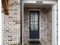 Inviting front entrance with a black door, sidelight, brick surround, and house number at 2021 Towneship Trl, Roswell, GA 30075