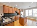 Well-lit kitchen featuring wood cabinets, granite countertops, stainless steel appliances and a kitchen island at 572 Vinings Estates Se Dr # B9, Mableton, GA 30126