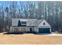 Charming new construction farmhouse featuring a 2-car garage, stone accents, and a covered front porch at 34 Harmony Ridge Dr, Temple, GA 30179