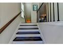 Bright staircase with dark wood steps, white risers, and decorative railings at 376 Provenance Dr, Atlanta, GA 30328
