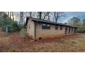 Charming brick home showcasing backyard with tree coverage and gate at 868 Maxey Hill Ct, Stone Mountain, GA 30083