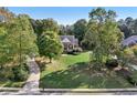 Expansive front lawn and mature trees surround this inviting home with a charming, classic facade at 9435 Grande Dr, Winston, GA 30187
