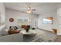 Bright living room with a large sofa, area rug, ceiling fan, and mounted television at 2783 Bayrose Cir # 83, Atlanta, GA 30344