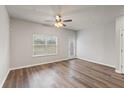 Minimalist living room with light gray walls, wood-look floors, ceiling fan and a door to the outside at 2783 Bayrose Cir # 83, Atlanta, GA 30344