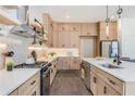 Modern kitchen featuring stainless steel appliances, quartz countertops, light wood cabinets, and hardwood floors at 61 Newcastle Sw St, Atlanta, GA 30314