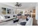 Bright living room with large windows, modern furniture, and a ceiling fan that opens to kitchen and dining area at 61 Newcastle Sw St, Atlanta, GA 30314