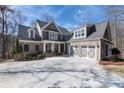 Beautiful two-story home with brick and siding, a three-car garage and a circular driveway in a landscaped setting at 6880 Nantucket Cv, Cumming, GA 30041